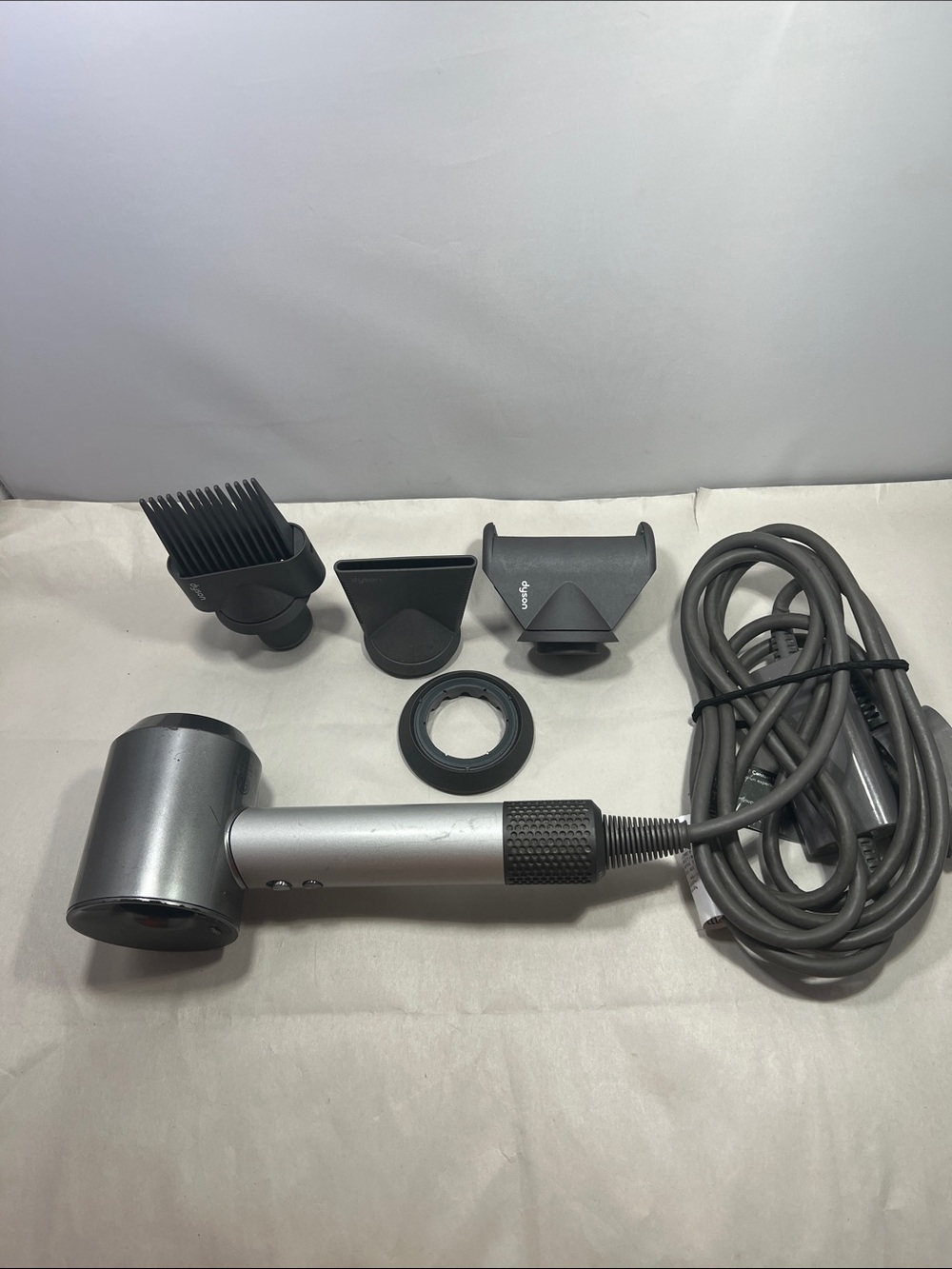 Dyson Hair Dryer with Multiple Dark Gray and Silver Styling Attachments